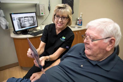 dentist showing a patient how all-on-4 dental implants work