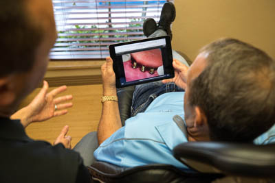 dentist showing a patient how dental implants work