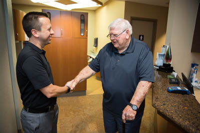 Dr. Matthew R. Burton shaking hands with a patient