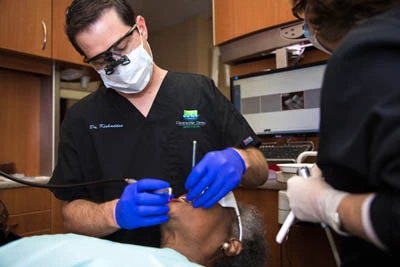 Dr. Matthew R. Burton working on a patient's teeth during her restorative dentistry appointment